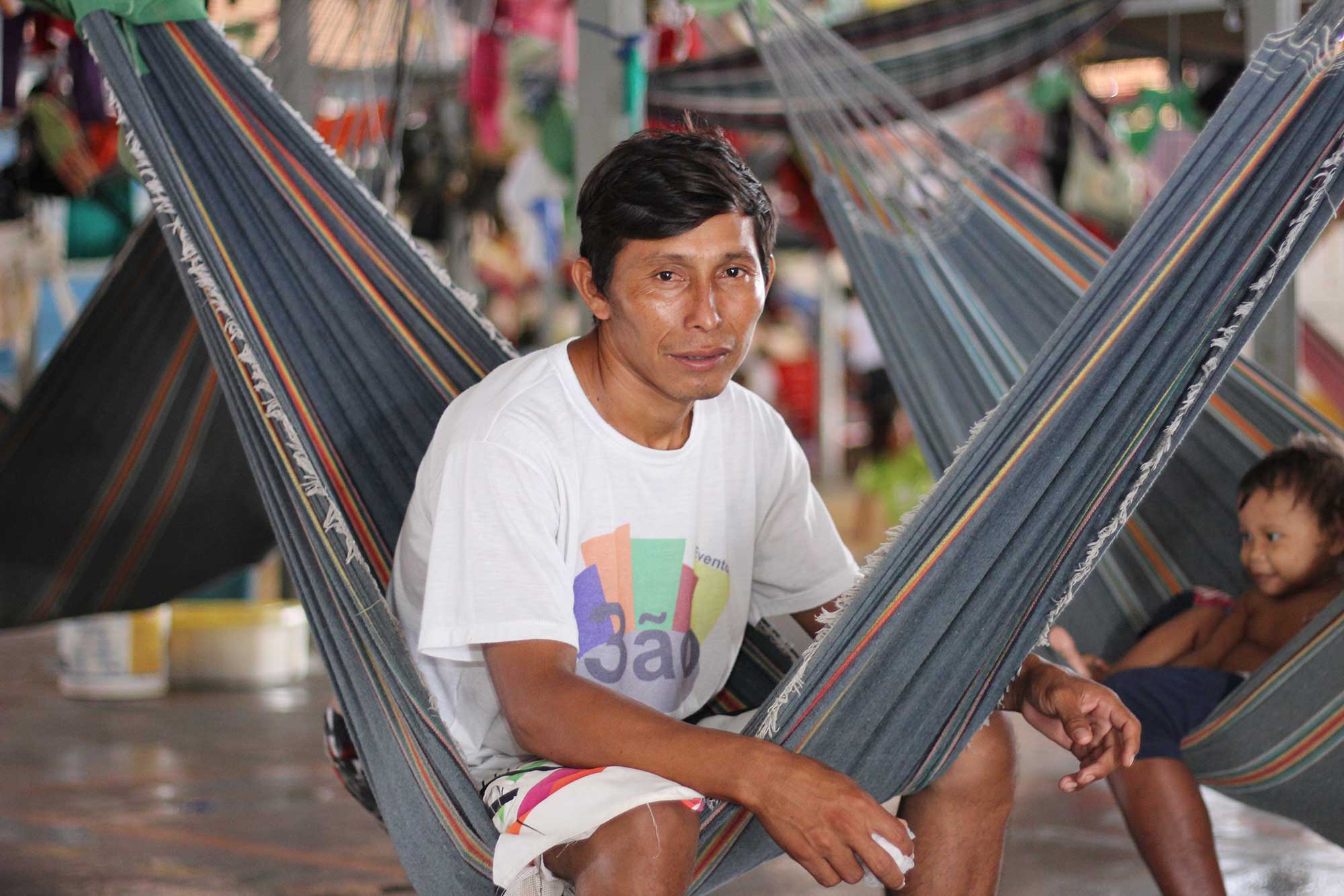 Warao community leader, Eligio Tejerina, 33, sits in a hammock with his children at Pintolandia Shelter in Boa Vista, northern Brazil.
